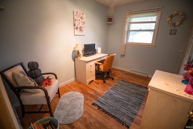 home office featuring a baseboard radiator and light wood-type flooring