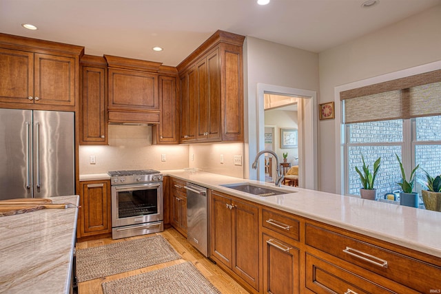 kitchen with stainless steel appliances, light wood-type flooring, and sink