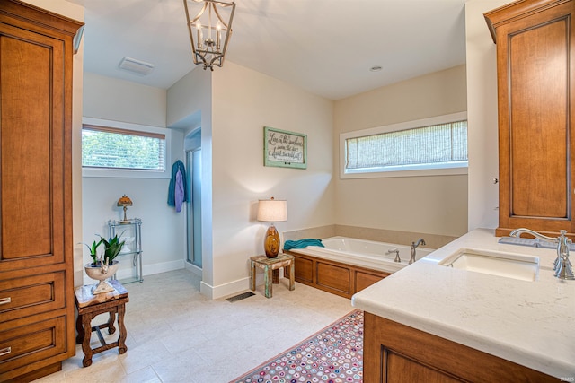 bathroom featuring vanity, a notable chandelier, and a bath