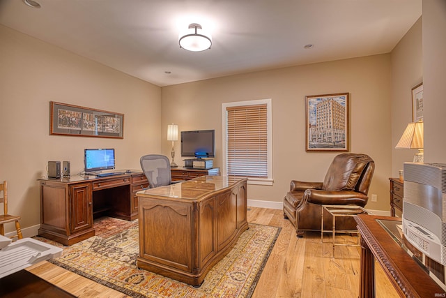 home office with heating unit and light hardwood / wood-style flooring