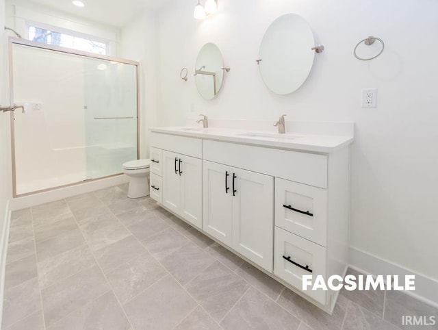 bathroom featuring a shower with door, vanity, and toilet