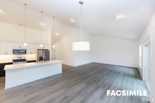 kitchen featuring high vaulted ceiling, a kitchen island with sink, hardwood / wood-style flooring, white cabinetry, and appliances with stainless steel finishes