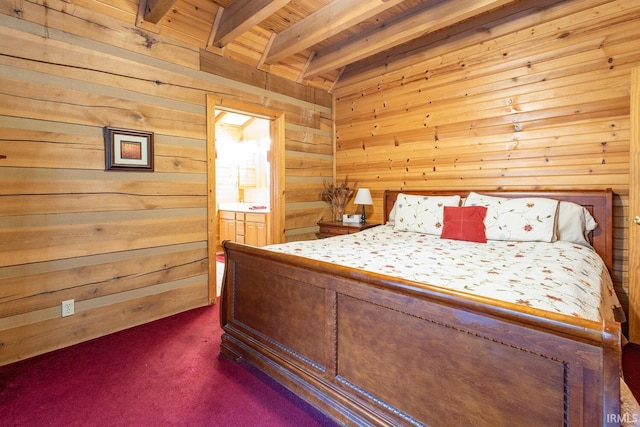 unfurnished bedroom featuring dark carpet, beamed ceiling, wooden walls, wooden ceiling, and ensuite bathroom