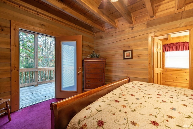 carpeted bedroom featuring multiple windows, wooden walls, beamed ceiling, and access to outside