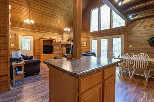 kitchen featuring beam ceiling, dark wood-type flooring, high vaulted ceiling, a center island, and an inviting chandelier