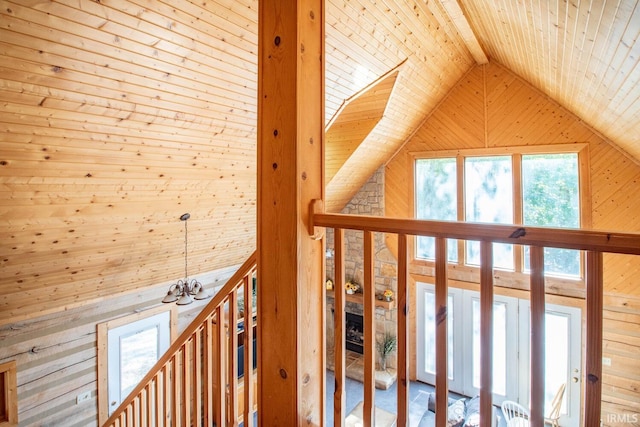 corridor featuring wood ceiling, lofted ceiling with beams, a chandelier, and wooden walls