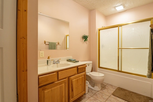 full bathroom featuring a textured ceiling, toilet, tile patterned floors, bath / shower combo with glass door, and vanity