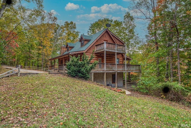 rear view of house featuring a wooden deck and a lawn