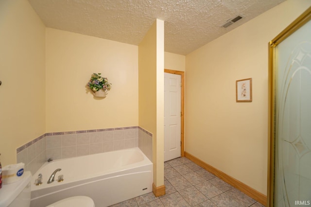 bathroom featuring tile patterned flooring, a textured ceiling, and a washtub