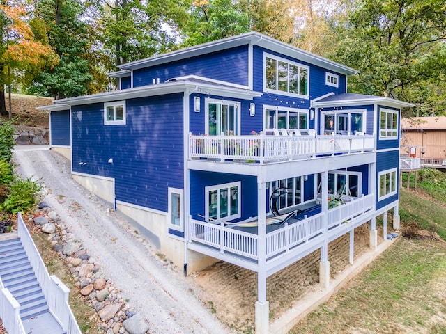 rear view of house featuring a balcony and a deck