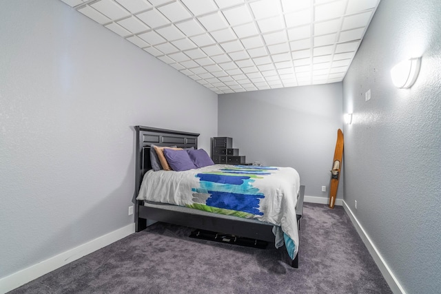 carpeted bedroom featuring a drop ceiling