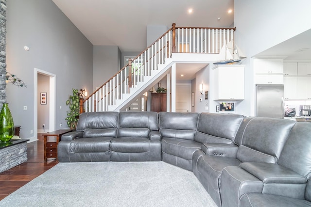 living room featuring dark wood-type flooring and a towering ceiling