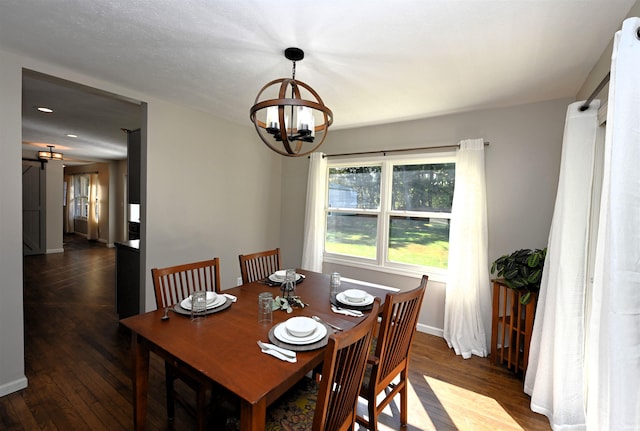 dining room with a notable chandelier, dark hardwood / wood-style floors, and a barn door