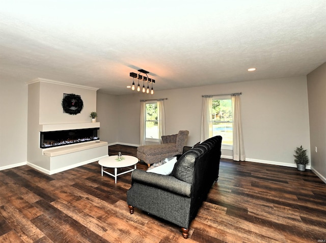 living room featuring dark wood-type flooring and a textured ceiling