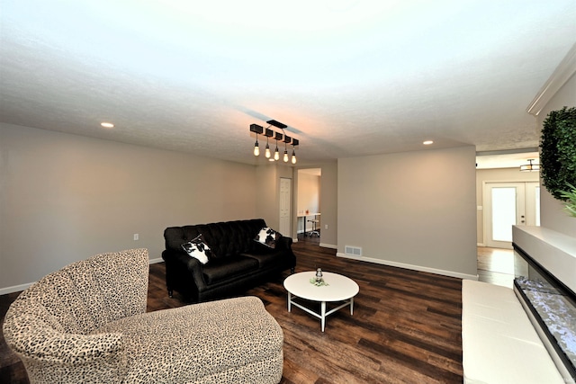 living room featuring dark hardwood / wood-style floors and a textured ceiling