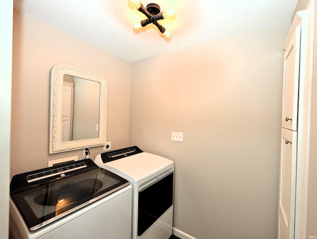 laundry area featuring washing machine and clothes dryer and cabinets