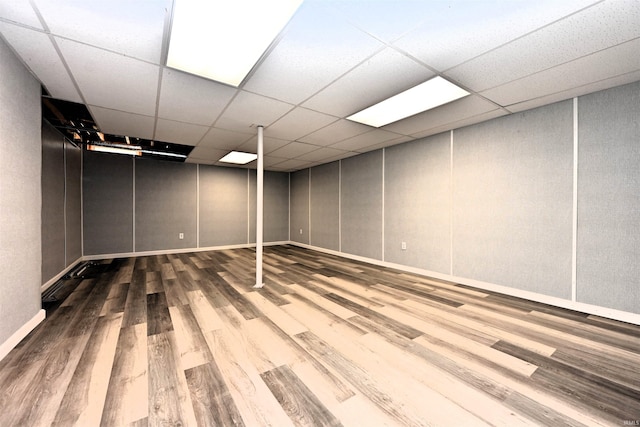 basement featuring hardwood / wood-style flooring and a paneled ceiling