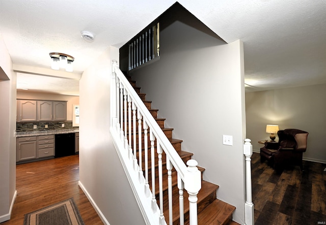 staircase featuring hardwood / wood-style floors and a textured ceiling