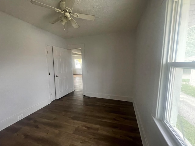 unfurnished room with ceiling fan, dark hardwood / wood-style flooring, and a textured ceiling