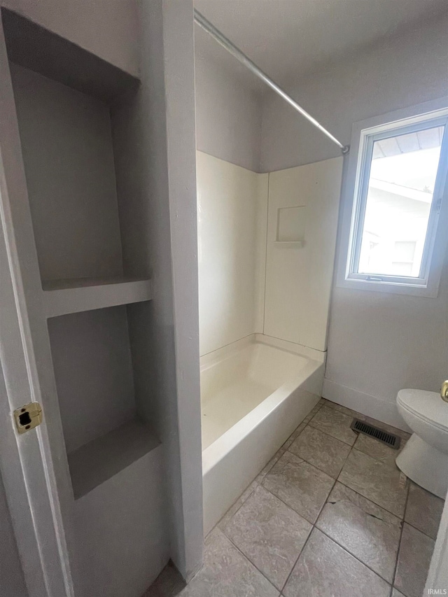 bathroom with shower / washtub combination and toilet