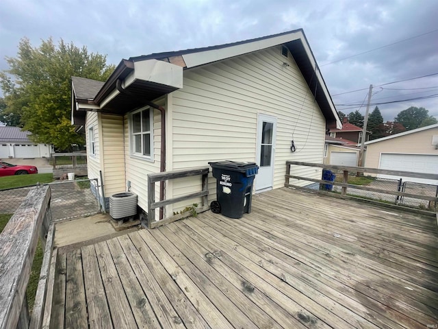 deck with a garage and central air condition unit