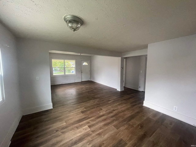 spare room with dark hardwood / wood-style floors and a textured ceiling