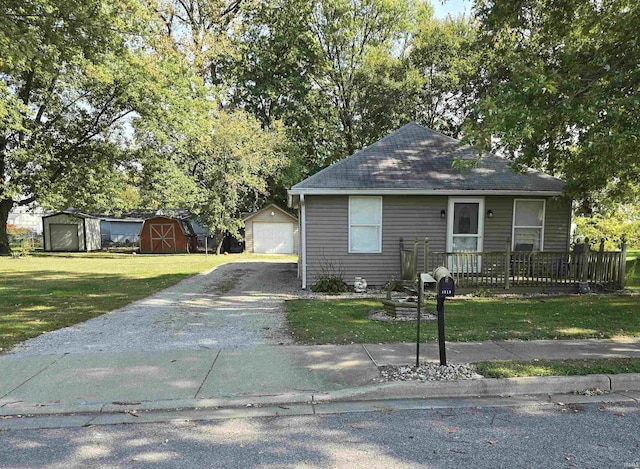 view of front of house with a garage, a shed, and a front lawn