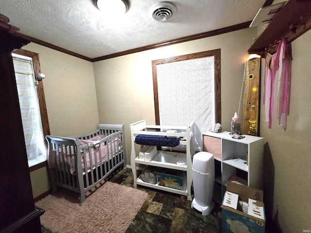 bedroom with a crib, a textured ceiling, and crown molding