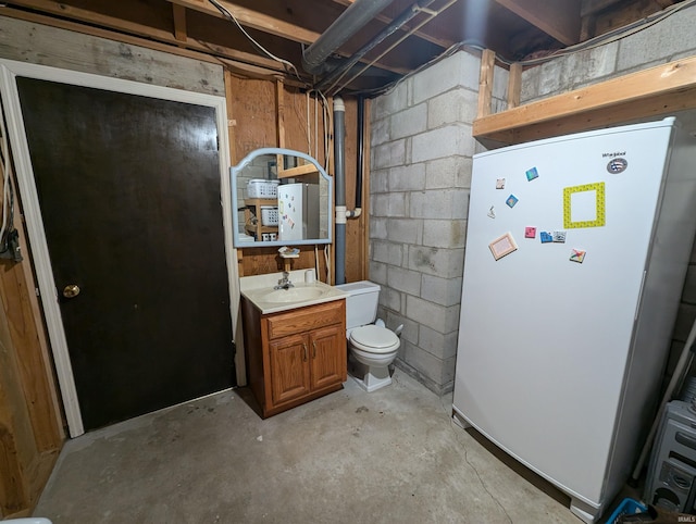 interior space with toilet, vanity, and concrete floors