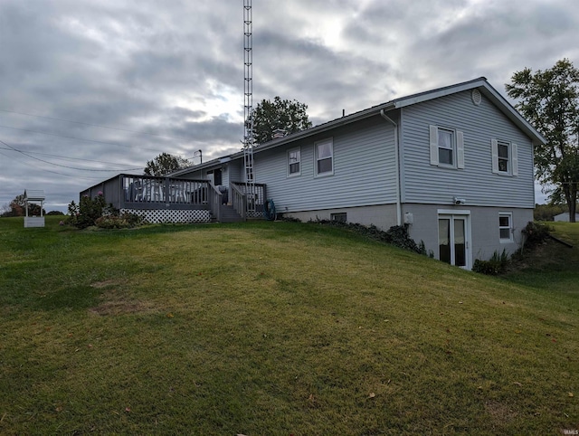 back of house featuring a yard and a wooden deck