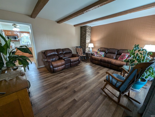 living room with beamed ceiling and dark wood-type flooring