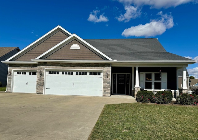 craftsman inspired home featuring a garage, a front lawn, and covered porch