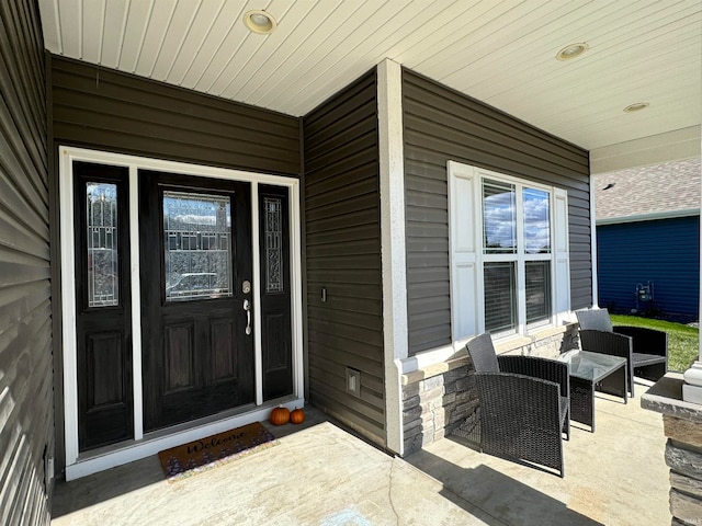 view of exterior entry featuring covered porch