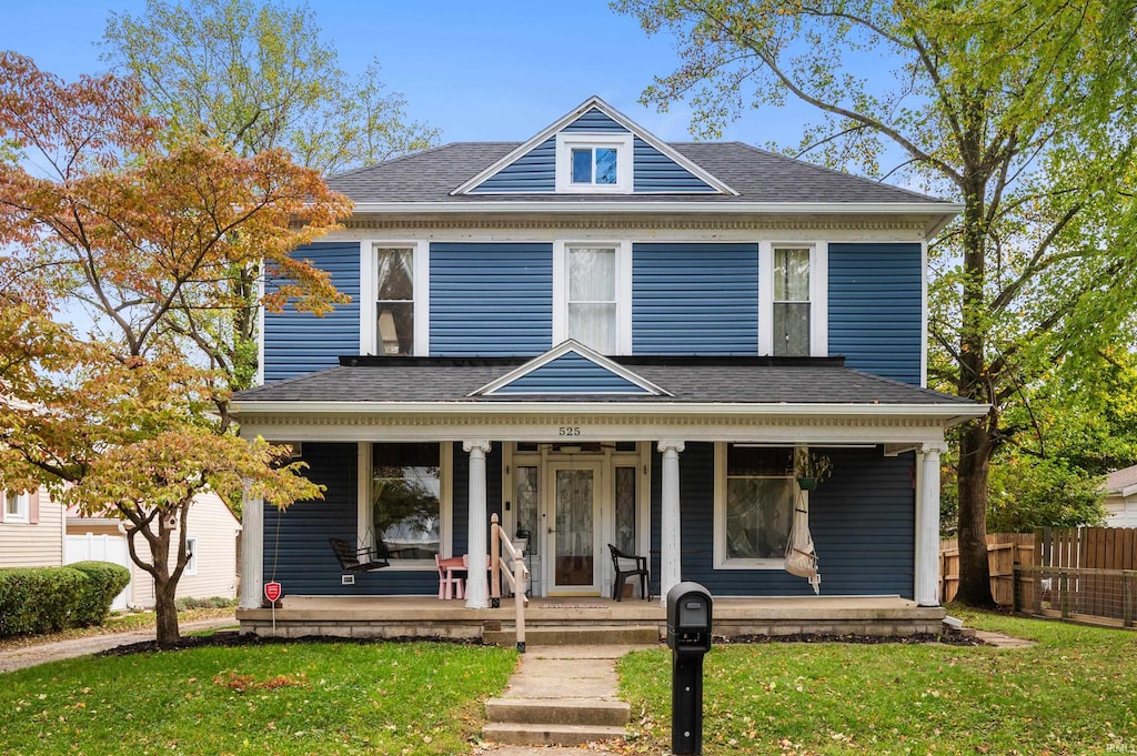 view of front of house with a front yard and a porch