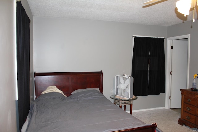 carpeted bedroom with a textured ceiling and ceiling fan