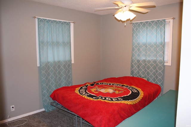 carpeted bedroom featuring ceiling fan and a textured ceiling