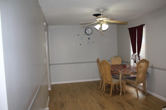 dining room featuring ceiling fan, wood-type flooring, and a textured ceiling