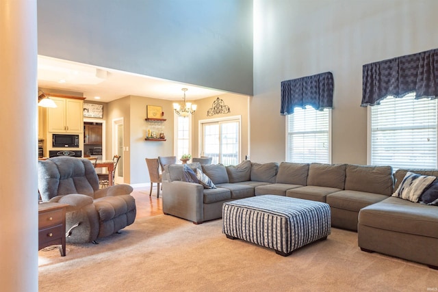 carpeted living room with a chandelier