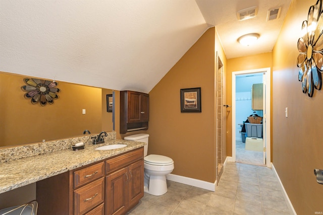 bathroom featuring lofted ceiling, vanity, tile patterned floors, toilet, and a textured ceiling