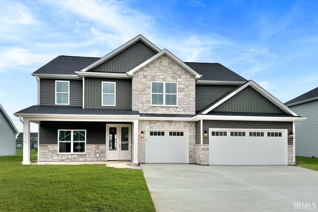 craftsman house with covered porch, a garage, and a front yard