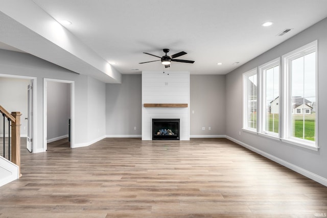 unfurnished living room with a fireplace, light hardwood / wood-style floors, and ceiling fan