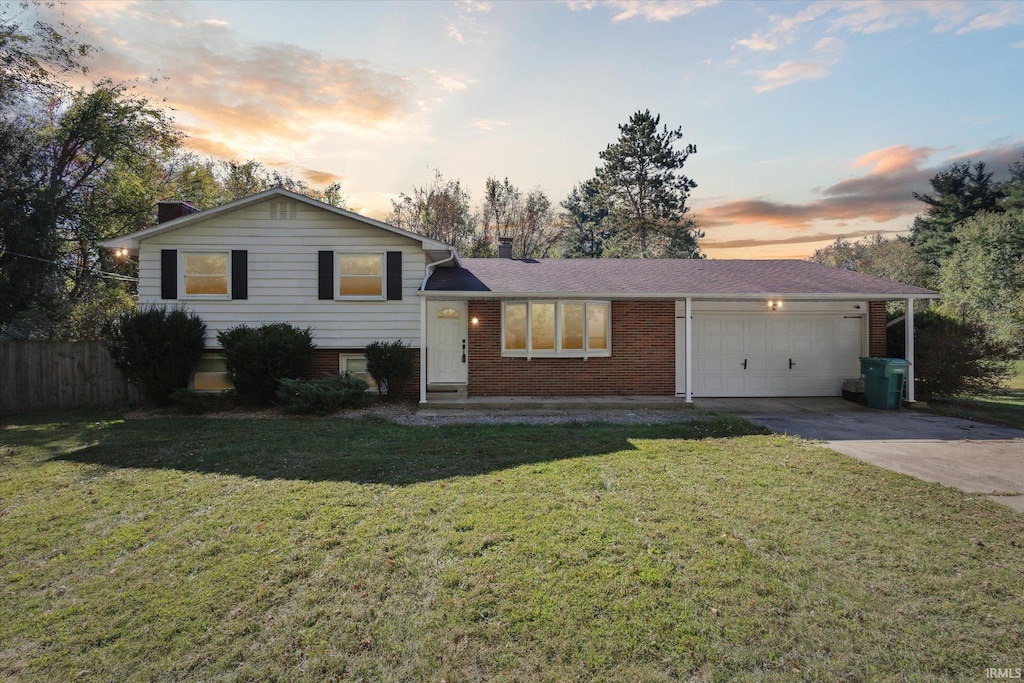 split level home featuring a lawn and a garage