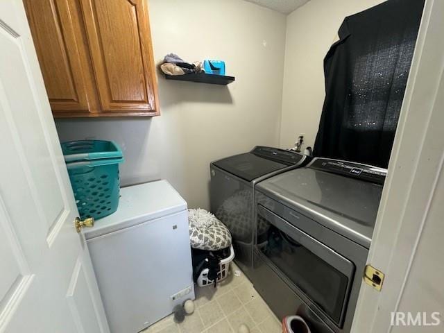 laundry area featuring washing machine and dryer and cabinets