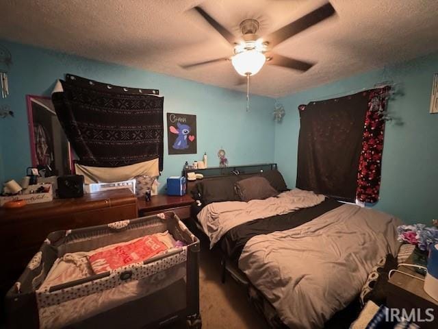 bedroom featuring ceiling fan, carpet floors, and a textured ceiling