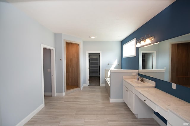 bathroom featuring a washtub and vanity