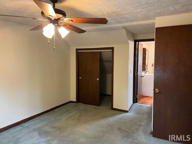 carpeted empty room featuring ceiling fan and a textured ceiling