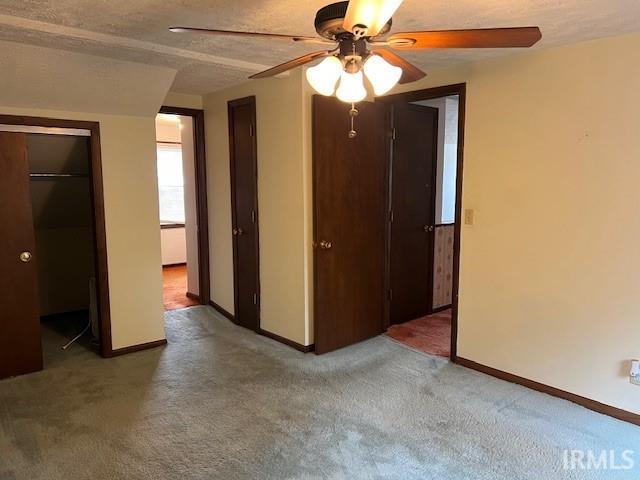 unfurnished bedroom featuring ceiling fan, a textured ceiling, and carpet floors