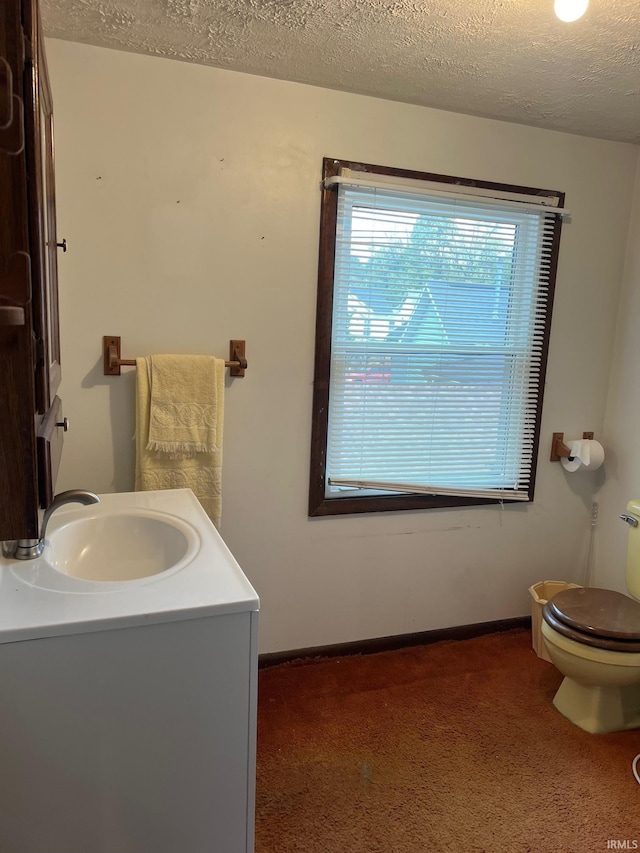 bathroom with vanity, toilet, and a textured ceiling