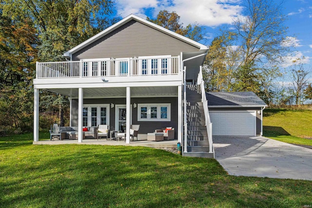 rear view of property with outdoor lounge area, a patio, a yard, and a garage