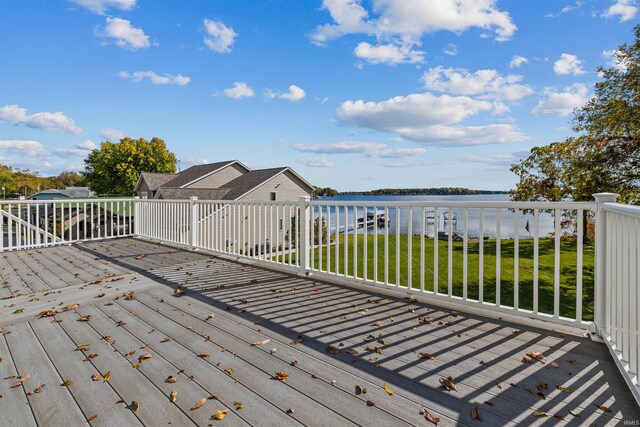 deck with a water view and a yard